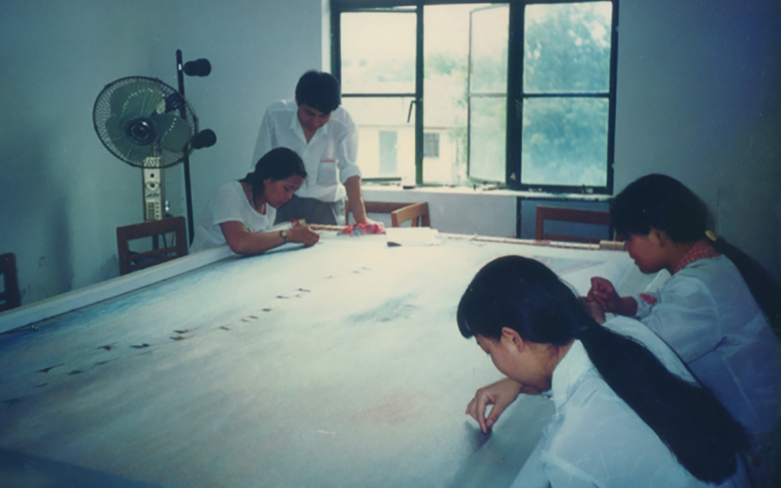 扬州市礼好一然绣研究院苏绣贺礼：情牵香港回归的匠心之作朱军成大师在指导学生绣制归程的场景.jpg
